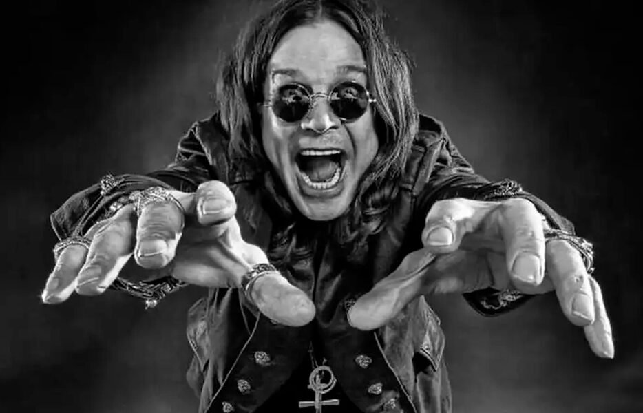 Um jovem Ozzy Osbourne, no final dos anos 60, em preto e branco, em uma encruzilhada de uma rua industrial de Birmingham. De um lado, uma fábrica sombria; do outro, um palco com uma luz brilhante. Ele está olhando para o palco com uma expressão de determinação. O estilo é de uma foto de filme granulado, dramático, alta resolução, proporção 16:9.