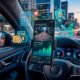 gere a imagem: Uma ilustração 3D conceitual e moderna voltada para o planejamento financeiro e mobilidade. Em primeiro plano, o volante de um carro moderno com um smartphone acoplado exibindo um mapa de aplicativo de transporte e um gráfico financeiro em tom verde ascendente, representando o aumento do lucro. Ao redor do celular, flutuam ícones holográficos sutis: moedas de ouro, uma calculadora, um escudo e o símbolo de porcentagem (redução de juros e custos). O fundo mostra uma metrópole iluminada ao entardecer com leve desfoque de movimento nas luzes da rua, transmitindo a dinâmica do trabalho e a visão de longo prazo. Estilo hiper-realista, corporativo e inspirador. Alta resolução, proporção 16:9 (820x468)